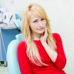 women in dental room in dilemma for root canal vs extraction of her tooth