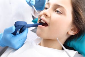 The dentist is performing a root canal treatment to the patient.